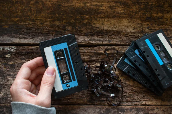 Man håller ett kassettband på ett träbord — Stockfoto