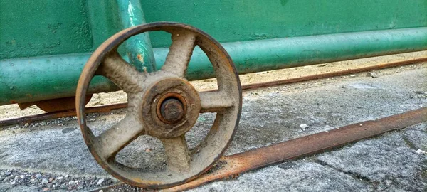 the rusty iron wheel of the old gate of an old abandoned building