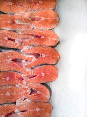 Parçalara ayrılmış taze ve lezzetli balıklar. Beyaz buzda nefis somon bifteği.