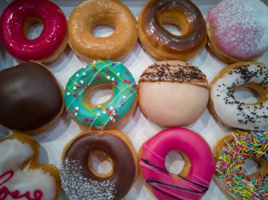 Farklı tatlarda lezzetli yuvarlak zencefilli çörek. Bazıları çikolata ya da karamel ile doldurulur. Beyaz bir kutunun içinde renkli şekerler. 