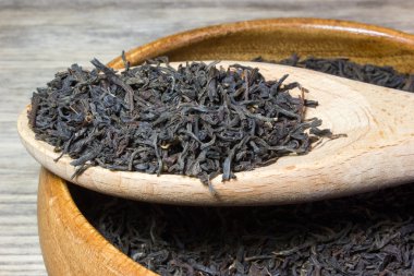 Kuru çay siyah çay için ahşap arka plan üzerinde bırakır.