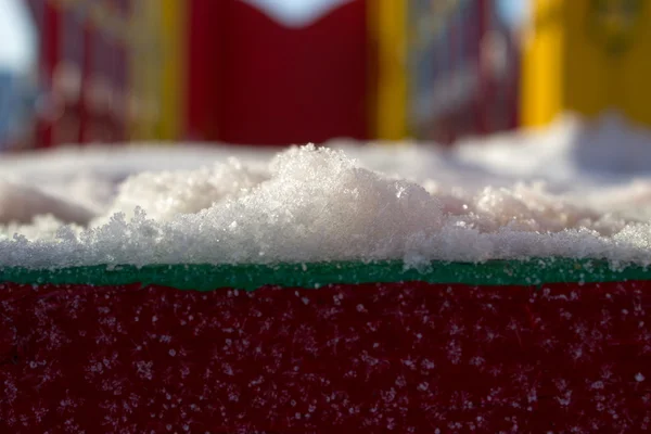 Primeros planos de nieve sobre un fondo rojo de madera — Foto de Stock