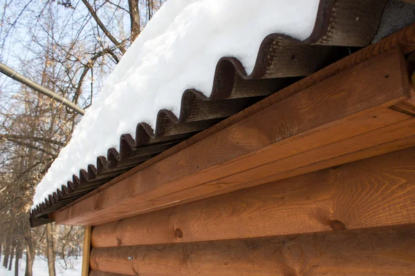 La nieve en el techo de una casa de madera — Foto de Stock