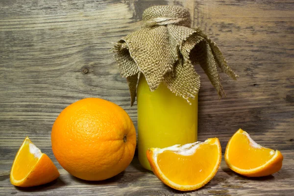 Arance e succo d'arancia fresco su fondo di legno — Foto Stock