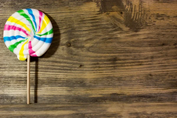 Ronde spiraal kleur candy op houten achtergrond. — Stockfoto