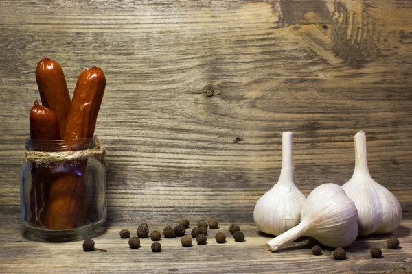 Räucherbierwurst mit Knoblauch und Gewürzen auf Holzgrund. — Stockfoto