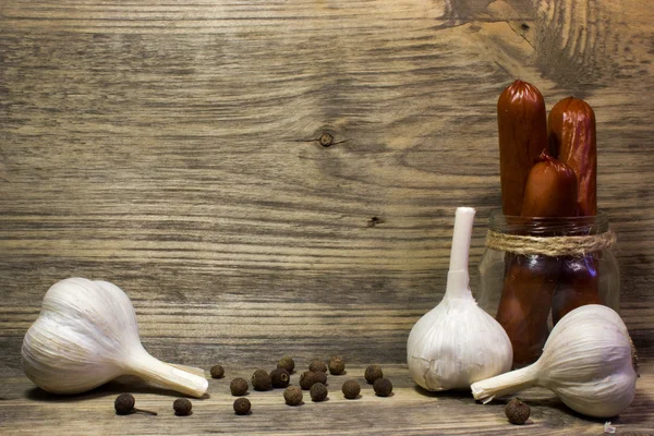 Räucherbierwurst mit Knoblauch und Gewürzen auf Holzgrund. — Stockfoto