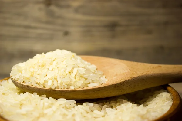 Granos de arroz en plato de madera —  Fotos de Stock