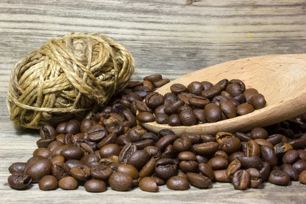 Coffee beans in wooden spoon on wooden background — Stock Photo, Image