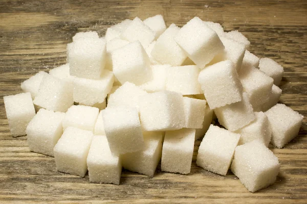 Kostki cukru na drewnianym tle — Zdjęcie stockowe