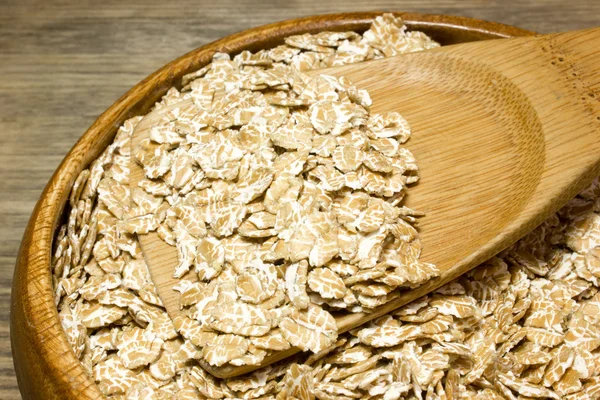Пшеничні пластівці в дерев'яній ложці на дерев'яному фоні — стокове фото