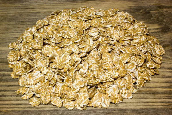 Пшеничні пластівці на дерев'яному фоні — стокове фото