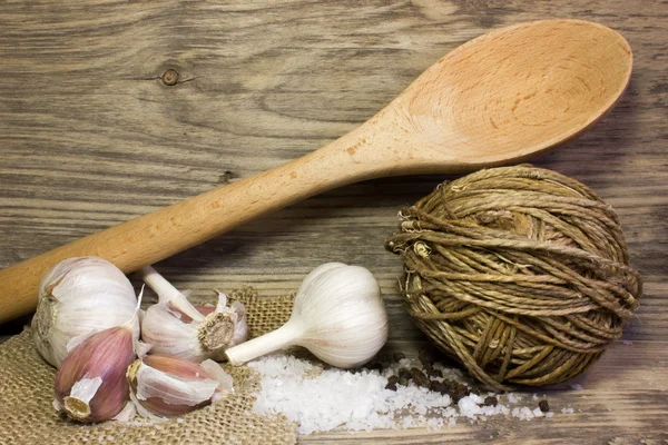 Trä kök sked, vitlök, havssalt på trä bakgrund. Utrymme för text. — Stockfoto