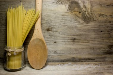 Makarna spagetti ve tahta kaşık ahşap arka plan üzerinde