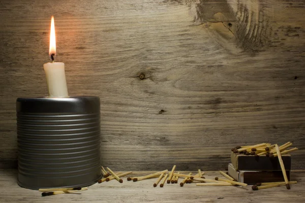 Partidos y una vela encendida sobre fondo de madera — Foto de Stock