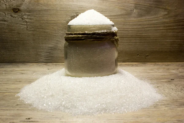 Açúcar em jarra de vidro no fundo de madeira — Fotografia de Stock