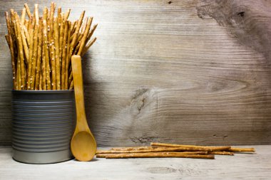 Ahşap arka plan üzerinde teneke bir kutuda tuz ile ekmek sopa