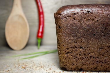 Ahşap arka planda siyah çavdar ekmeği.