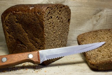 Ahşap arka planda siyah çavdar ekmeği.