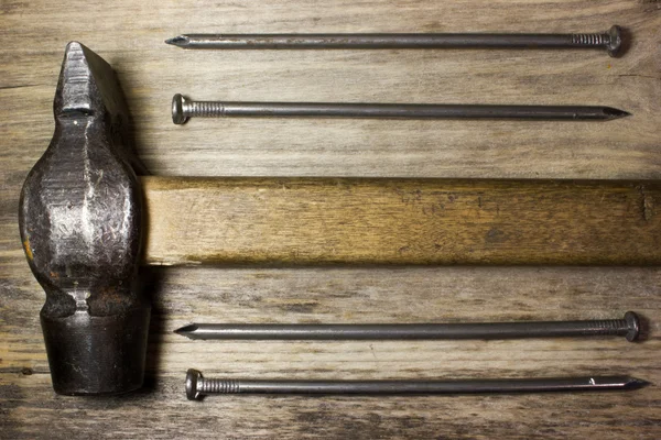 Hammer und Nägel auf hölzernem Hintergrund — Stockfoto