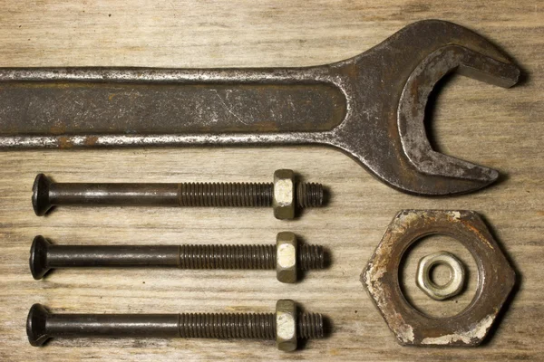 Wrench, nuts and bolts on wooden background — Stock Photo, Image