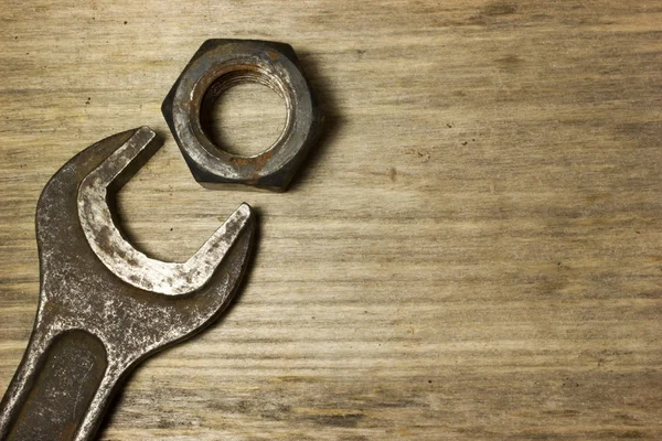 Wrench, nuts and bolts on wooden background — Stock Photo, Image