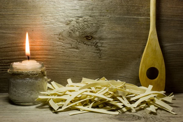 Ampia tagliatelle italiane e cucchiaio di legno su sfondo in legno — Foto Stock