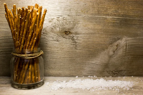 Bread sticks with salt on wooden background — Stock Photo, Image