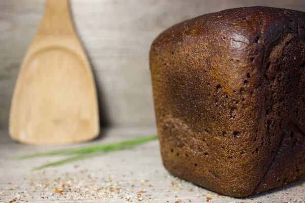 Pan de centeno negro sobre fondo de madera. — Foto de Stock