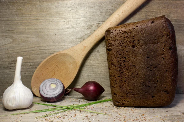 Pan de centeno negro sobre fondo de madera. — Foto de Stock