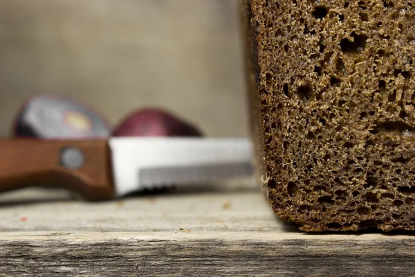 Pan de centeno negro sobre fondo de madera. — Foto de Stock