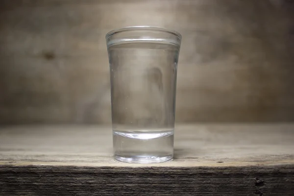 Um copo de vodka na mesa de madeira . — Fotografia de Stock