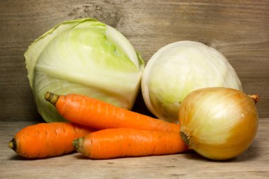 Lahana, soğan ve havuç ahşap arka plan üzerinde