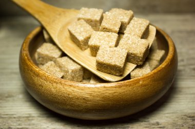 Küpleri kahverengi şeker kamışı ve ahşap zemin üzerine kaşık