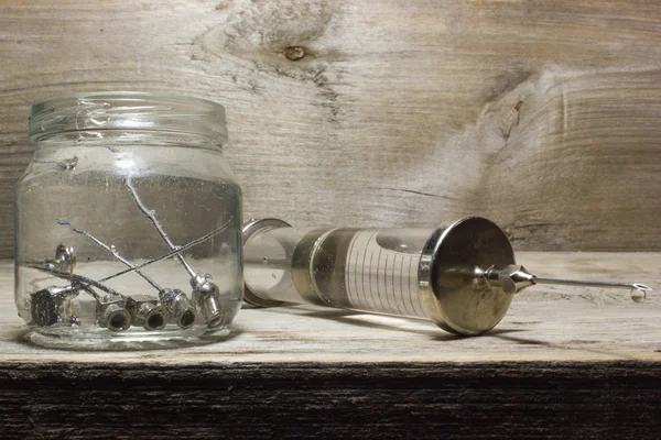 Seringue en verre vintage en fer avec aiguilles sur fond en bois . — Photo