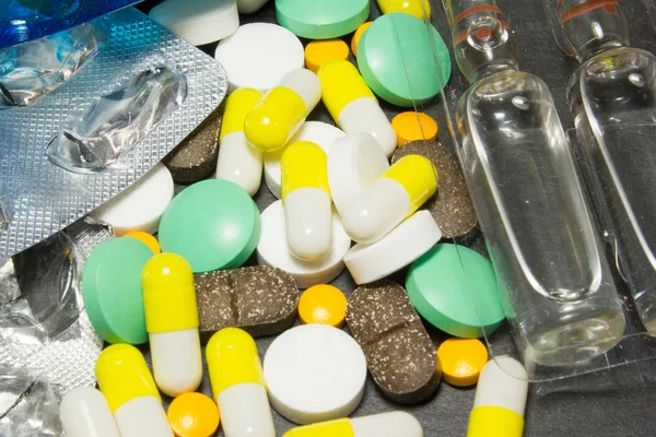 Таблетки лекарства на темном фоне — стоковое фото
