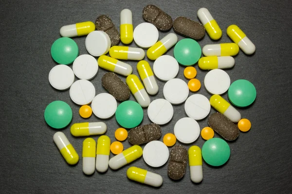 Таблетки лекарства на темном фоне — стоковое фото
