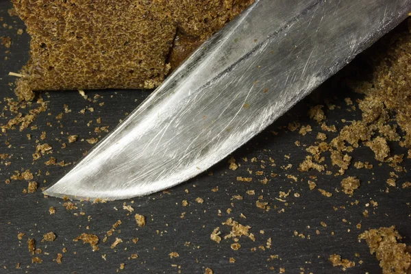 Pão de centeio preto e uma faca — Fotografia de Stock