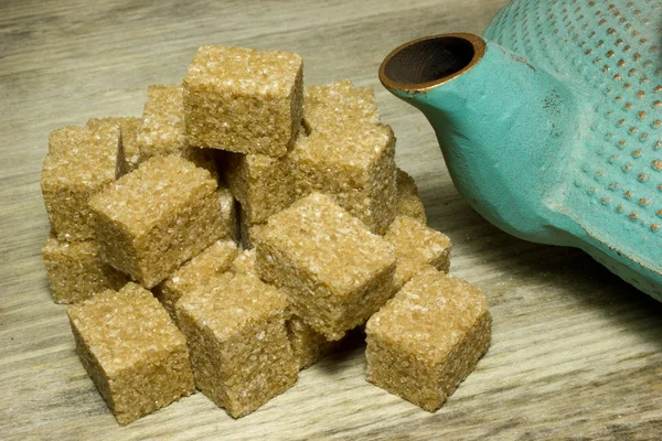 Moduły brązowego cukru trzcinowego na drewniane tła — Zdjęcie stockowe