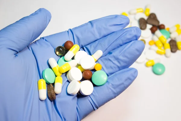 Таблетки лекарства в руке на белом фоне — стоковое фото