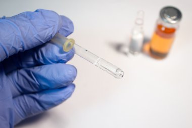 Bir el ve bir şişe beyaz arka plan tıbbi pipet