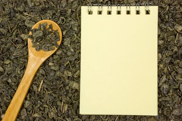 Suché, zelený čaj, prázdný list papíru a dřevěnou lžící. Místo pro text — Stock fotografie