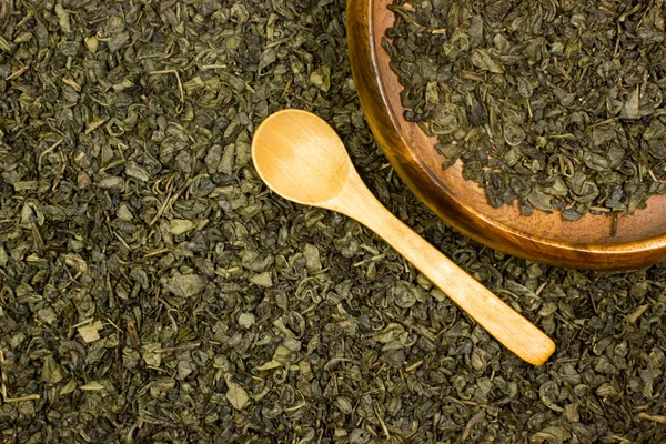 Grüner trockener Tee und Holzlöffel — Stockfoto