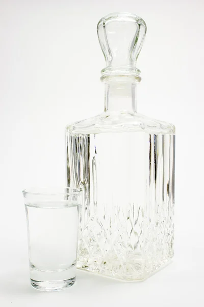 Carafe et verre de vodka sur blanc — Photo