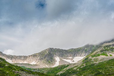 Rocky Ridge 'in panoramik manzarası. Ufuktaki dağlar bulutlu gökyüzünün altında. Güneşli bir günde dağ vadisinde dolaşmak.