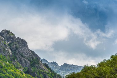 Rocky Ridge 'in panoramik manzarası. Ufuktaki dağlar bulutlu gökyüzünün altında. Güneşli bir günde dağ vadisinde dolaşmak.