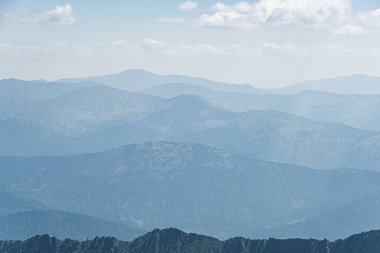 Ufukta tepe olan sakin dağ vadisi manzarası. Mavi sisli yumuşak tepeler.