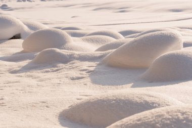 Güneşli kış gününde yumuşak kar yağışı olur. Derin ve yüksek kar sürükleniyor. Güneş ışığıyla aydınlanıyor ve gölgede kalıyor.
