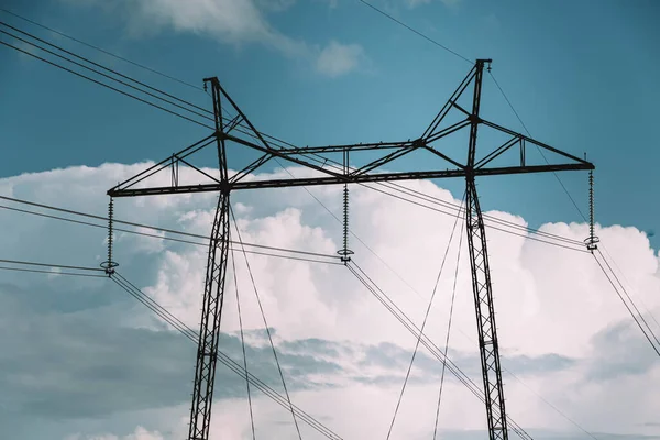 空と雲に対する送電線の塔 電力会社からの電線による電気の伝送 高電圧パイロンとラインの風景 — ストック写真