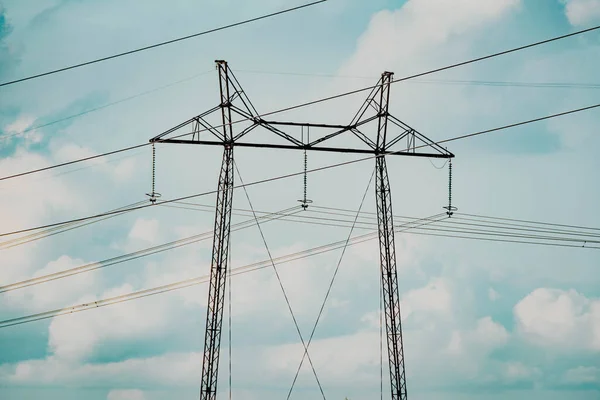 空と雲に対する送電線の塔 電力会社からの電線による電気の伝送 高電圧パイロンとラインの風景 — ストック写真